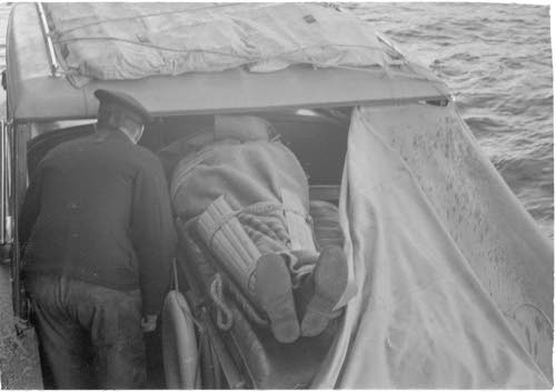 Haavoittunut on asetettu pikamoottoriin, jolla kuljetetaan sairaalalaivalle. Örö 1941.10.27